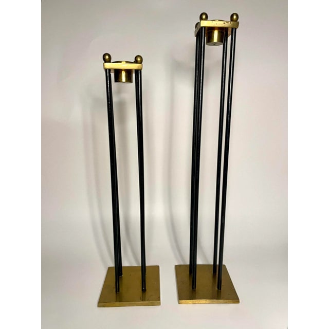 There's a streamline and classic look to this pair of contemporary modern candlesticks. Four small black metal cylinders...