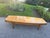 Vintage mid-century modern long burlwood coffee table features a rectangular wood-grain top with tapered legs and dark-...