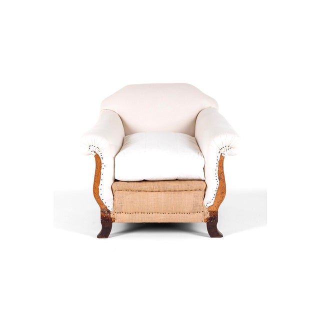 A wonderful deconstructed low armchair with a deep seat and shapely wide back complemented with generous gently scrolling...