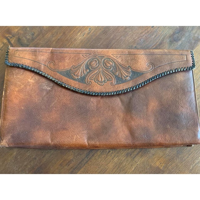 Beautiful antique Meeker leather handbag featuring intricate hand-tooled floral decoration and a warm, rich brown leather...