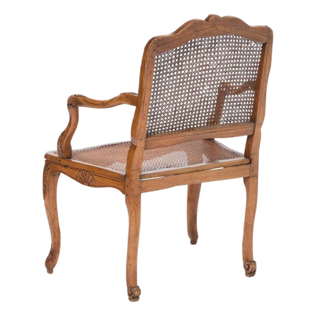 A charming Louis XV style armchair crafted in walnut with hand carved Rococo detailing throughout. The shaped crest rail,...