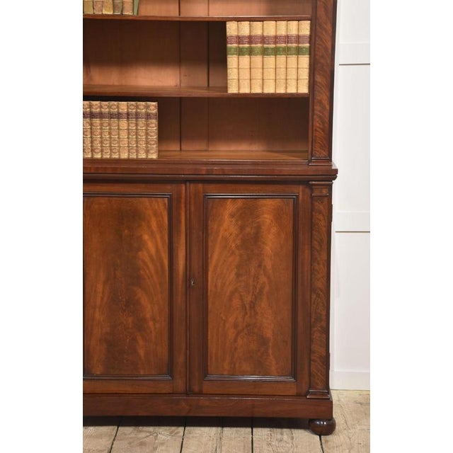 19th-century mahogany open bookcase, the rectangular top with moulded cornice above the adjustable shelved interior...