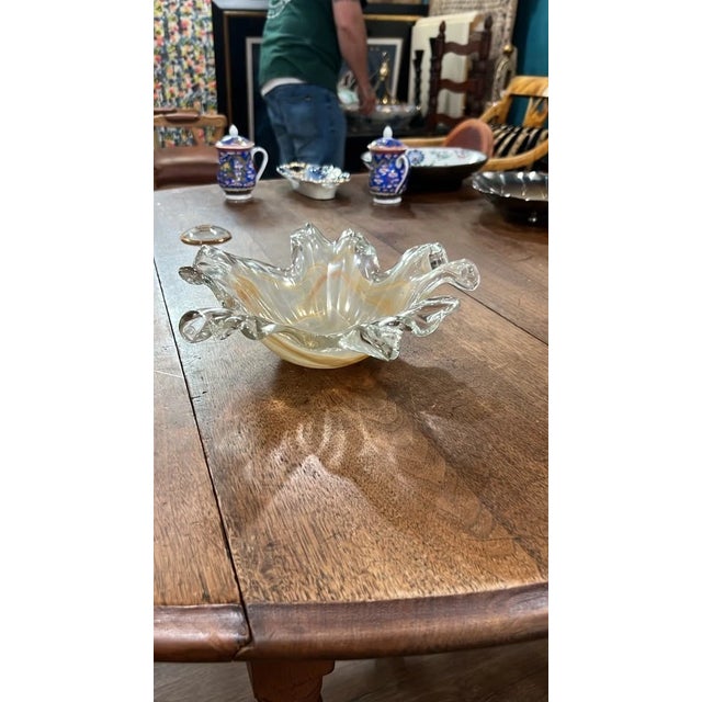 Add dynamic texture and warm light to your space with this vintage hand-blown art glass bowl. Featuring dramatically...
