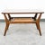 American designed coffee table with laminate top surface and cane shelf below. Sculptural wood legs throughout. Unsigned.