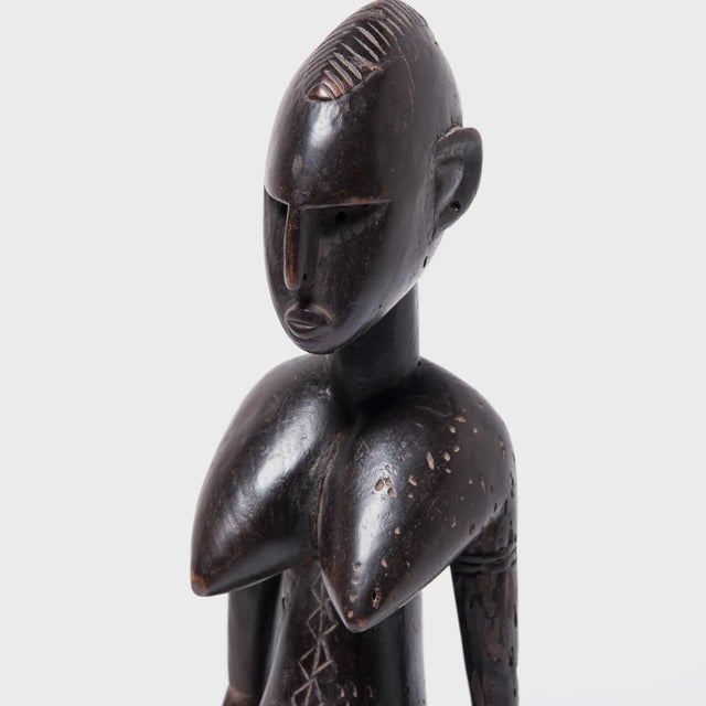 With ripe curves, refined facial features, and etched scarification marks along the torso, this female figure embodies the...