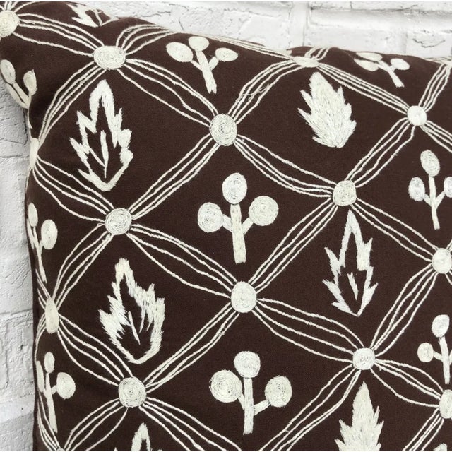 Custom-tailored rich chocolate brown pillow with decorative creamy-white floral embroidery. Double-sided print, piped in...