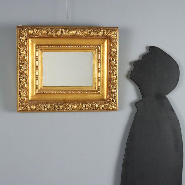 Carved and gilded wood mirror from 20th century Italy, featuring a frame with double molding. The inner molding is...