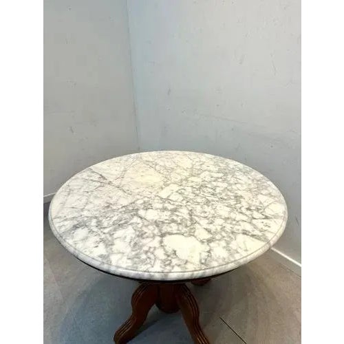 Elegant round table with a solid white marble top and beautifully carved wooden pedestal base. This timeless piece...