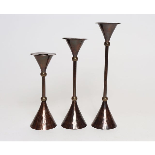 Set of three graduated hammered brass candlesticks made in India for Rosenthal Netter (ca. early 1980s). Chic...
