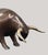 A contemporary animal bronze of a bull head-down mid-charge, tail flicked high and horns lowered to strike — the whole...