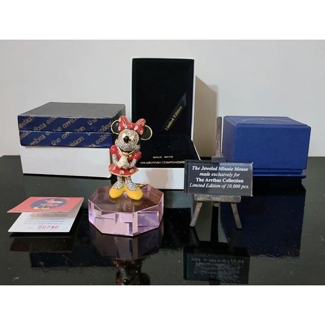 This exquisite “Cristal by Arribas Bros Collection” features a jeweled Minnie Mouse figurine (#790 out of a limited...