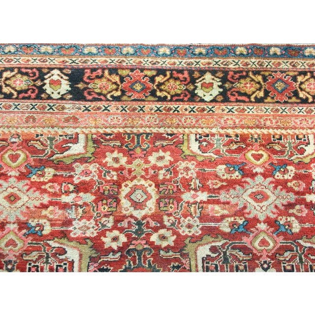 A stunning early 20th century Persian Meshkabad rug with an all-over floral pattern containing myriad large-scale flowers,...