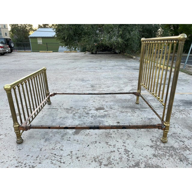 Heavy brass plated double bed frame with large ball mounts hand pounded iron rivets still present along the gilded cast...