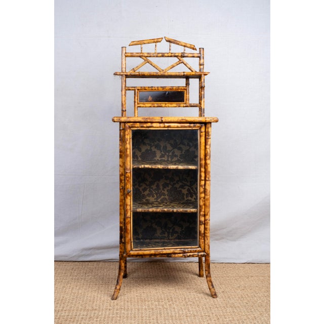 An antique tiger bamboo display cabinet, late 19th century, English. Made in the Anglo-Japanese style of the Aesthetic...