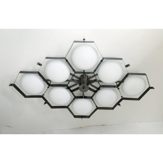 Italian midcentury flush mount with eight matte white Murano glass shades mounted on solid brass frame in satin black...