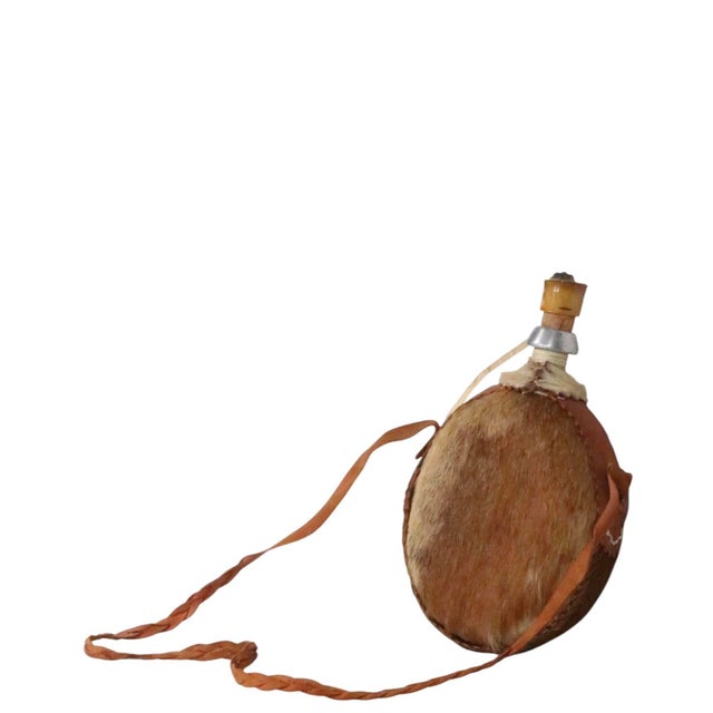 Vintage canteen, water jug, featuring a hide covered exterior over an aluminum body, with a woven leather cary strap. We...