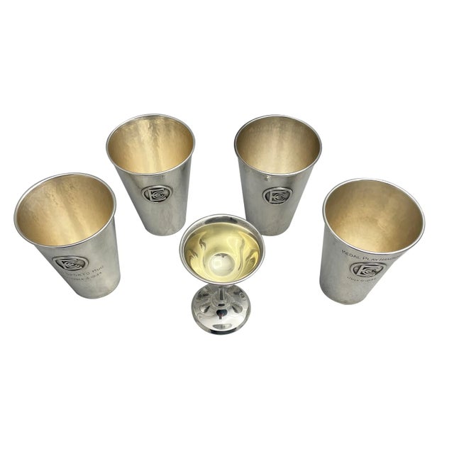 A set of American sterling silver mint julep cups. Sold as a set of 5. Four mint julep cups together with a matching...
