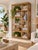 Beautiful vintage coastal bookcase or étagère crafted from natural rattan with woven cane shelf surfaces. Features an eye-...