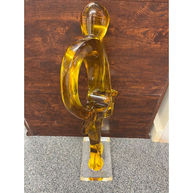 This Haziza Amber Lucite Saxophone Player Sculpture is a breathtaking celebration of music and movement, beautifully...