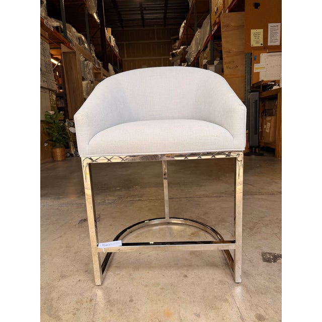 Contemporary counter stool featuring crisp light blue upholstery with elegant horizontal channel stitching across the...