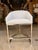 Contemporary counter stool featuring crisp light blue upholstery with elegant horizontal channel stitching across the...