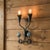 Twin Blooms in Iron Elevate your interior lighting from mere function to high art with the Hand Forged Botanical Twin Lily...