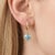 These elegant drop earrings feature radiant Blue Topaz gemstones, beautifully suspended from sleek gold hoops for a...