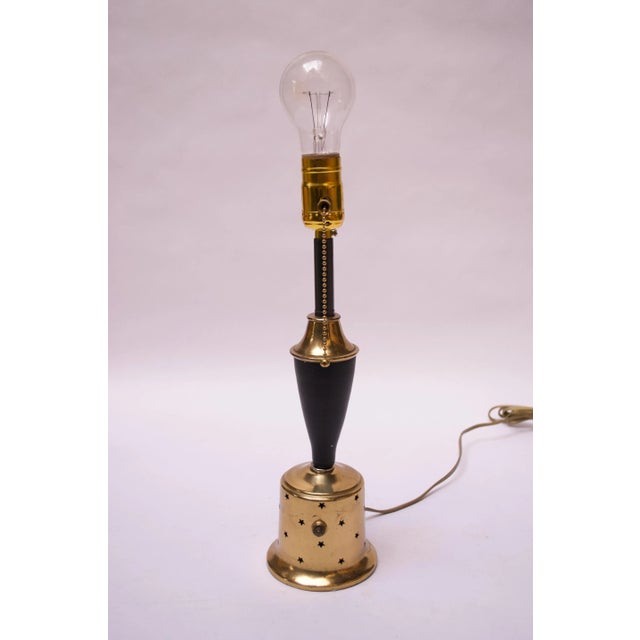 Mid-Century American Modern brass table lamp with original black metal stem with perforated star decoration. Two light...