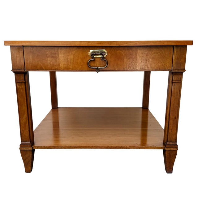 A sophisticated pair of side tables by Baker Furniture in a French Regency style. They feature book-matched cherry wood...