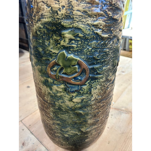 Beautiful textured and glazed ceramic umbrella stand in the Arts & Crafts style having earth colors and oak leaf decoration.