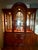 Solid cherry breakfront china cabinet by Pennsylvania House with a lighted arched display cabinet, beveled glass doors,...