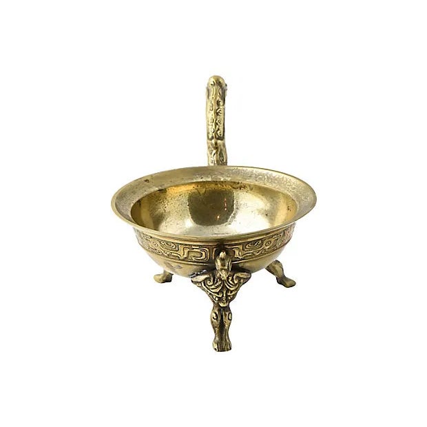 Interesting mysterious raised brass bowl with a dragon handle and bird feet. There is a raised design on the outside that...