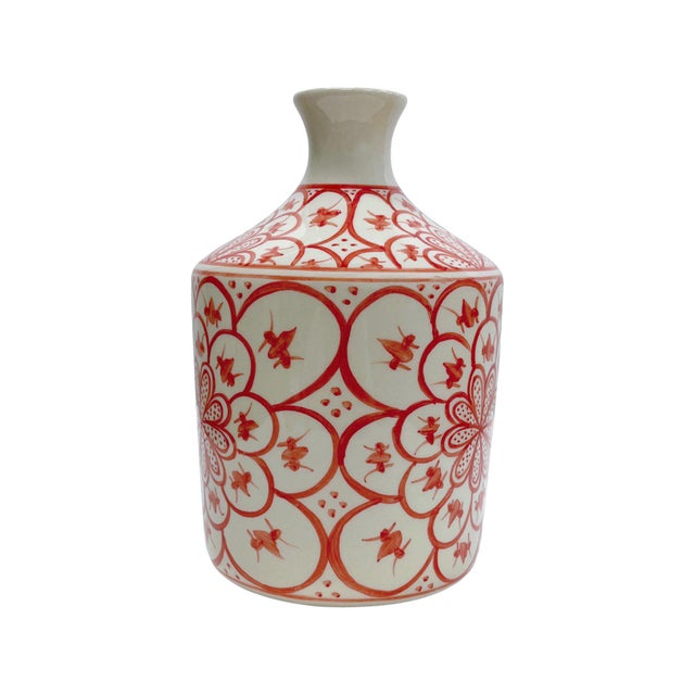 This handcrafted ceramic vessel features a vibrant red floral motif inspired by Mediterranean artistry. The intricate...