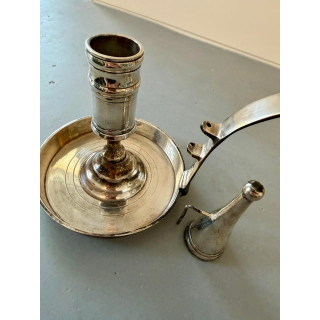Early 20th Century silver plate weighted chamberstick with long handle and attached snuffer. This solid candle holder with...