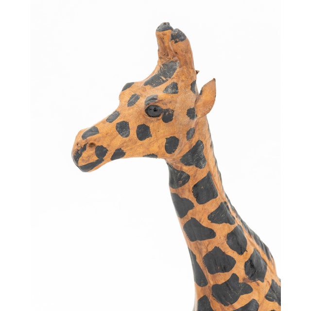 Two Standing Giraffe Hand-Painted Leather Sculptures, each with inset glass eyes. Taller: 10.25" H x 5.5" W x 2.5" D....