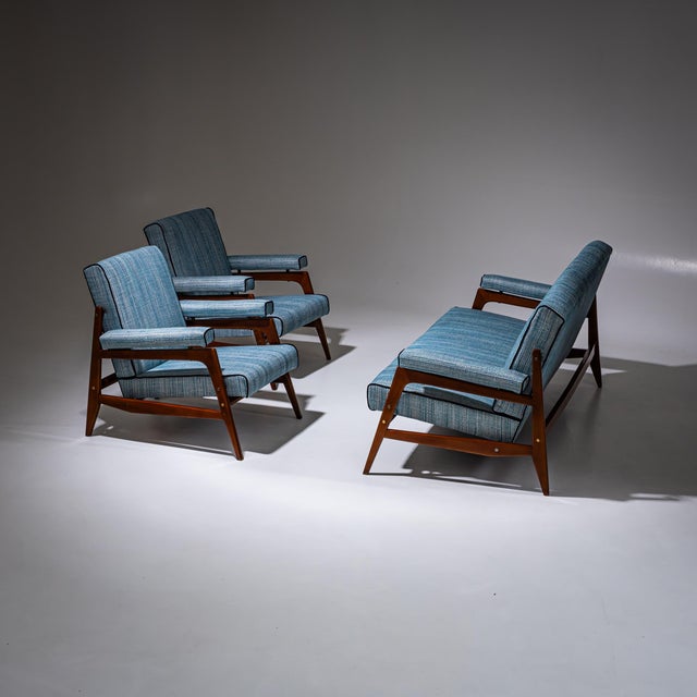 Mid-Century seating group consisting of a two-seater sofa and two armchairs. The armrests, seats and backrests are...