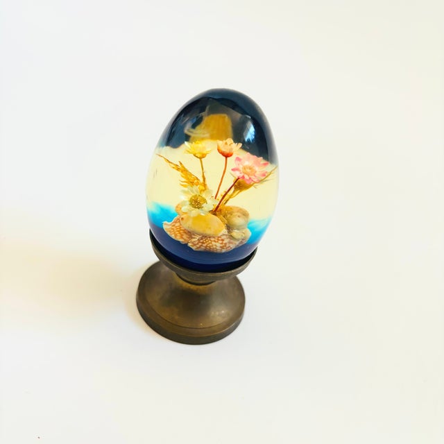 A wonderful vintage acrylic egg with a dried flower arrangement in the center. Blue base to the acrylic egg. Comes with a...