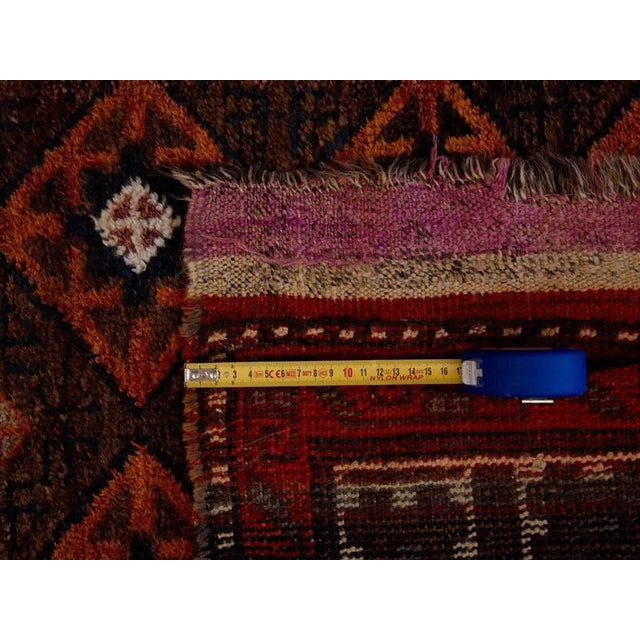 All-wool antique rug from the Shiraz region. Stylized geometric motif in earthy tones of brown. The rug has prominent...