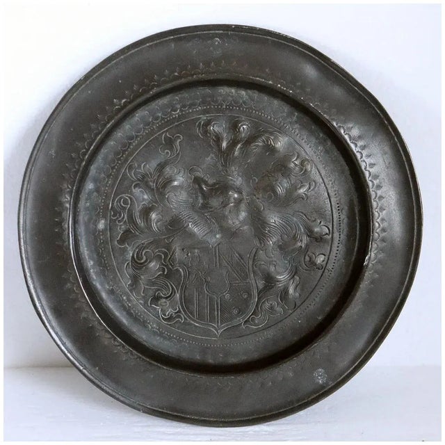 DETAILS An antique European plate of round shape with a large heraldic, coat of arms in the center. MARKS Faint touchmark...