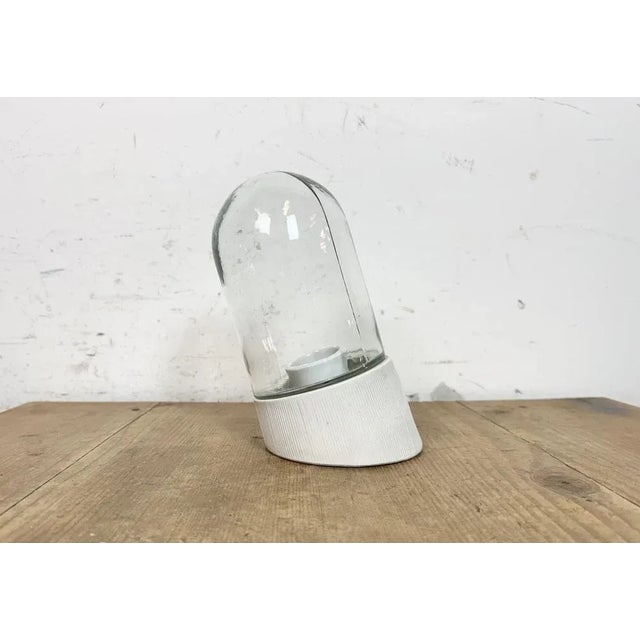 Vintage industrial light made in former Czechoslovakia the 1970s. It features a white porcelain wall mounting and a glass...