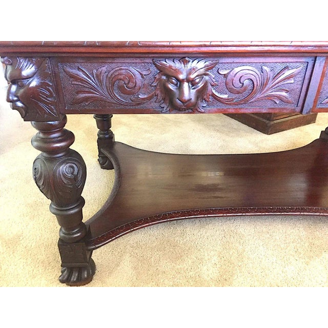 Offered is a Mahogany Carved Library Table, Partners desk, early 20th century. The piece features carved lion's masks on...
