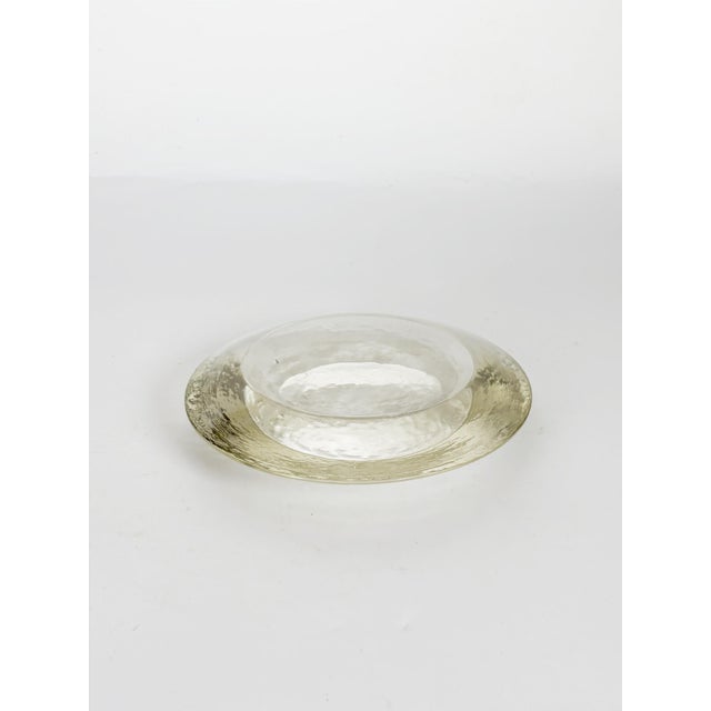 Elegant French glass ashtray dating from the 1970s, featuring a minimalist circular design with a softly hammered texture...