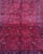 A richly saturated crimson field is covered in precise, repeating gul medallions — the hallmark motif of the Khal...