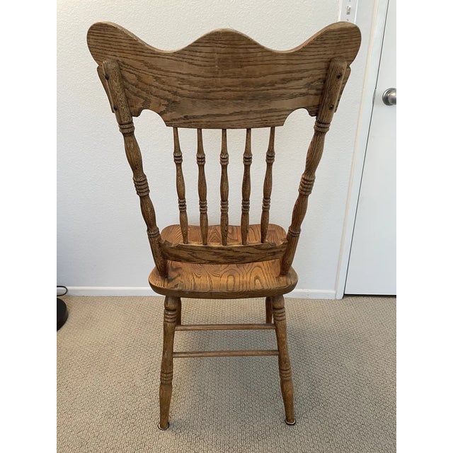 Beautiful antique solid oak press-back side chair featuring an elaborately embossed back with intricate floral scrollwork,...