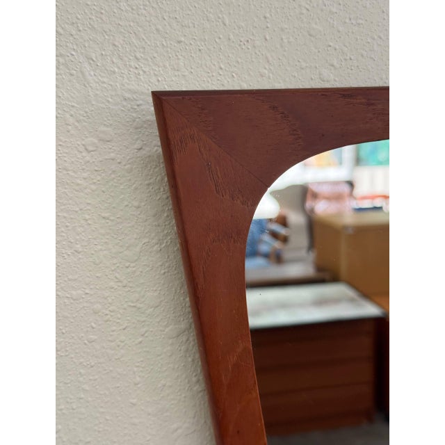 Danish wall mirror crafted in solid teak, produced by Aarhus Glasimport og Glassliberi in Aarhus, Denmark. This piece...