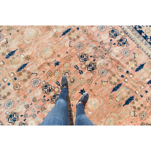 A large and quite charming rug with an allover floral motif for design. Features a soft color palette of salmon/brick...