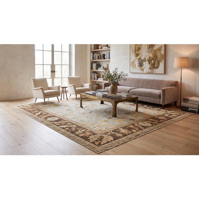 Elevate high-end interiors with this hand-knotted modern Oushak-style area rug, featuring an airy sky-blue field anchored...