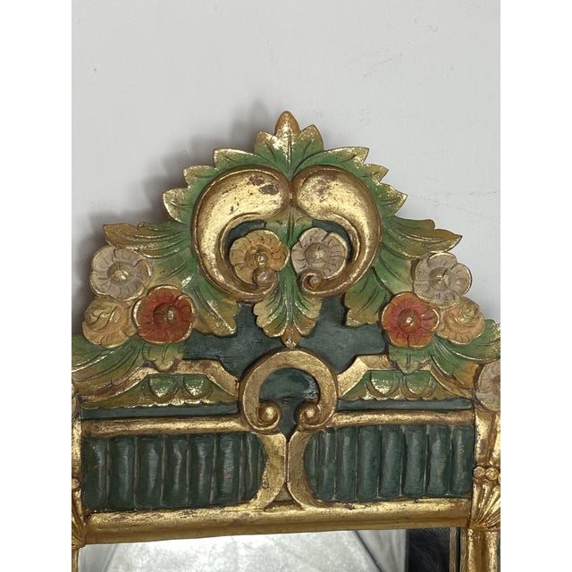 Charming solid wood mirror. The mirror is entirely carved and painted in pastel tones, with some elements gilded. Both the...