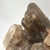 A visually dynamic smoky quartz crystal cluster, showcasing multiple sharply terminated points growing from a natural...