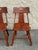 A pair of mid-century American side chairs in the distinctive Cushman style, characterized by sculpted saddle seats, broad...